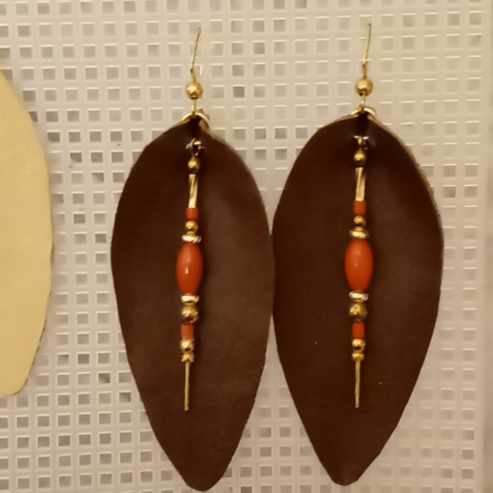 Dark brown teardrop earrings with coral stones.